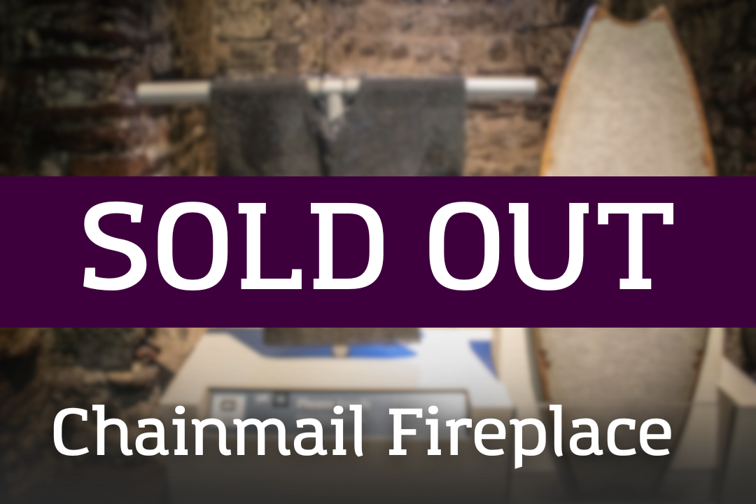 A display showing chainmail pieces arranged near a fireplace-like feature, overlaid with a “SOLD OUT” banner and the label “Chainmail Fireplace.”